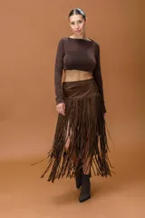 Falda midi de gamuza color marrón, con diseño de flecos largos en toda la parte inferior que aportan movimiento y estilo boho.