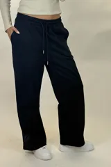Pantalon deportivo de corte recto y tiro medio, confeccionado en tejido de algodón con cintura elástica y cordón ajustable. Presenta un diseño holgado y cómodo.