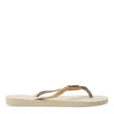 Sandalias tipo ojotas Havaianas modelo Slim Glitter II, color beige arena, con tiras finas cubiertas de glitter brillante.