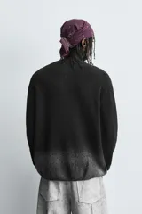 Jersey de punto de algodón con corte relajado, cuello redondo y manga larga. Presenta un diseño con estampado efecto spray degradado y acabados en rib.