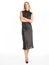Vestido midi de satén color champagne con corte al bies y escote recto, acompañado por un top sin mangas de cuello alto cubierto de lentejuelas doradas con detalle drapeado en la cintura.