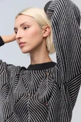 Sweater tejido gris oscuro con lurex plateado, cuello redondo y diseño geométrico calado en el frente.