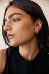 Aros de argolla en acero quirúrgico con dije de piedra natural en tono azul.