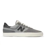 Championes urbanos New Balance modelo NM272LMP, color gris con detalles en negro, confeccionados en gamuza y lona, con logo "N" característico en los laterales y suela blanca.