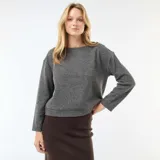 Sweater de punto color gris, de corte recto y largo a la cintura. Presenta cuello redondo y detalle de botones decorativos dorados en uno de los hombros.