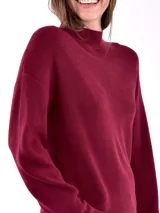 Buzo de tejido de punto en color bordó, con cuello alto y mangas largas con puños acanalados.