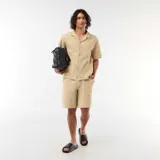 Bermuda de punto grueso color beige, de diseño liso, con bolsillos laterales y cintura elástica.