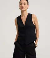 Chaleco negro de sastrería, corte slim, con escote en V profundo y cierre frontal de cuatro botones. Presenta bolsillos falsos o decorativos a la altura de la cadera.