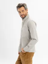 Camisa de corte regular confeccionada en tejido oxford, color azul claro. Presenta cuello con botones, cierre frontal abotonado, mangas largas con puños y un bolsillo frontal en el pecho.