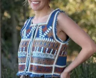 Chaleco corto en denim con bordado artesanal multicolor y escote cuadrado. Con cierre de botones y terminaciones desflecadas.