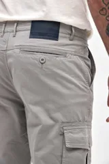 Pantalón cargo de gabardina en color gris, con corte standard slim. Presenta bolsillos laterales y bolsillos cargo con solapa y botones en los muslos.