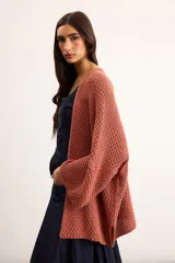 Saco tejido de punto con silueta oversize, color salmón, de manga caída y largo por debajo de la cadera.