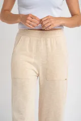 Pantalón de corte recto y tiro medio, confeccionado en tejido de algodón con textura acanalada. Presenta cintura elástica, bolsillos laterales y un calce holgado y cómodo.