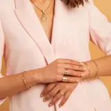 Anillo de oro 9k con diseño de grecas y una hilera central de circonias brillantes.