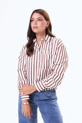 Camisa de manga larga con diseño de rayas verticales en color blanco y negro, cuenta con cuello clásico, cierre frontal de botones y un bolsillo en el pecho.