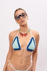 Top de bikini triangular tejido a crochet en color celeste y azul con borde festoneado en blanco.