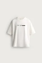 Remera de corte relaxed fit, color blanco, con cuello redondo y manga corta. Presenta un estampado frontal en contraste con la leyenda 'New York ESSENCE'.