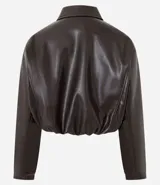 Campera de cuero sintético con diseño balonê, cuello camisero, cierre frontal con cremallera, mangas largas y ruedo elástico.