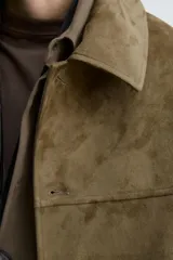 Cazadora regular fit color verde militar, confeccionada en tejido efecto ante. Presenta cuello solapa, manga larga, bolsillos de vivo en la cadera y cierre frontal de botonadura.