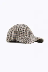 Gorra de béisbol con estampado de cuadros en tonos tostado, blanco y negro, confeccionada en tejido de textura suave.