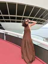 Vestido largo marrón de crepe texturizado, con cuello halter fruncido, diseño holgado y falda larga con vuelo.