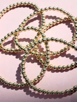 Pulsera elástica de cuentas de 4mm en oro laminado 14 kilates.