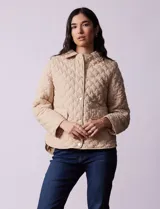 Campera capitoneada color beige, marca Weatherproof, con cuello con solapa, abertura central con botones metálicos, bolsillos delanteros y forro interno a tono.