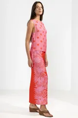 Musculosa liviana de viscosa y poliamida con estampado floral, lazos en los costados y calce ajustable.