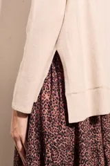 Sweater negro de cuello alto con tajos laterales y detalle de línea plateada en puños y ruedo.