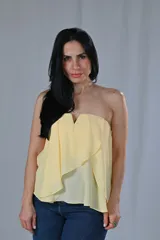 Top sin mangas color amarillo, con escote recto y volados diagonales en el frente.