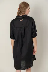 Vestido camisero corto de lino color celeste, con cuello clásico, cierre frontal con botones, mangas 3/4 con trabillas y bolsillo de parche en el pecho con bordado de iniciales.