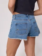 Short de jean azul con roturas y terminaciones desflecadas.