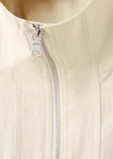 Chaqueta oversize color beige con cuello alto, cierre frontal de cremallera, bolsillos frontales con solapa y mangas largas.