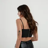 Top negro de cuero sintético con breteles finos y escote en V con fruncido central.
