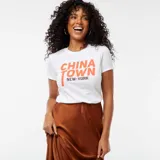 Camiseta blanca de algodón con estampado naranja con la frase "China Town New York".