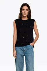 Musculosa negra de corte recto con escote redondo y aplicación de piedras brillantes dispersas por toda la prenda.