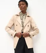 Buzo femenino modelo trench coat, confeccionado en poliéster con detalles acetinados. Posee cuello solapa, cierre delantero con 6 botones matizados y lazo con faixa pespontada.