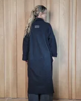 Sacón largo de punto abierto, confeccionado en lana, con diseño holgado, mangas anchas y cuello tipo solapa.