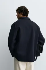 Sobrecamisa de corte regular confeccionada en tejido de lana doble faz, con cuello solapa, manga larga con puño abotonado, cierre frontal de botones y bolsillos de plastrón en pecho y cadera.