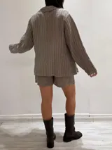 Blazer azul marino con rayas verticales blancas, confeccionado en lino italiano. Tiene botones de coco, solapas clásicas y bolsillos delanteros.