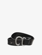 Cinturón de cuero negro con hebilla metálica grande de estilo rústico, con forma de letra 'C' o 'G' estilizada.