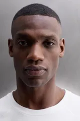 Camiseta de ajuste relajado (relaxed fit) color terracota, confeccionada en tejido técnico. Presenta cuello redondo, mangas ranglán cortas y un parche negro con logo en el bajo.