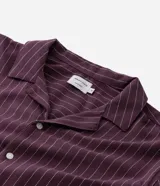Camisa de manga corta con cuello solapa, cierre frontal de botones y diseño a rayas verticales. Confeccionada en algodón con textura.
