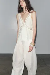 Top blanco de escote pico y tirantes finos, con detalle de encaje a tono y bajo recto.