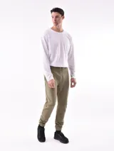 Pantalón de jogging negro, de corte ajustado con puños elásticos en los tobillos y cordón de ajuste en la cintura. Presenta paneles superpuestos en las rodillas y un pequeño texto vertical estampado en la pierna derecha.