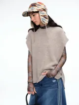 Chaleco de tejido de punto con lana y alpaca, de calce relajado y caída recta. Presenta aberturas laterales con botones y cuello redondo.