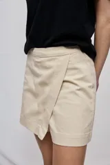 Short cruzado de tiro medio con diseño frontal tipo falda, color negro, de líneas simples y calce cómodo.
