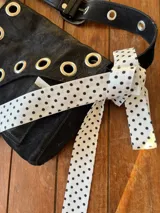 Corbatín blanco con lunares negros estilo polka dot.