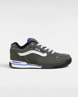 Zapatillas Vans Rowley XLT de color gris oscuro, con la franja lateral Sidestripe en blanco, pasador de cordones con etiqueta de la marca y detalles en azul. Presentan diseño robusto inspirado en el skate de los años 90 y 2000, con lengüeta acolchada y suela combinada en blanco y negro.