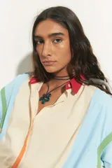 Collar con cordón azul oscuro y dije colgante de flor tridimensional de acrílico o vidrio soplado en tono azul verdoso.